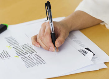 Hands writing notes on document, close-up