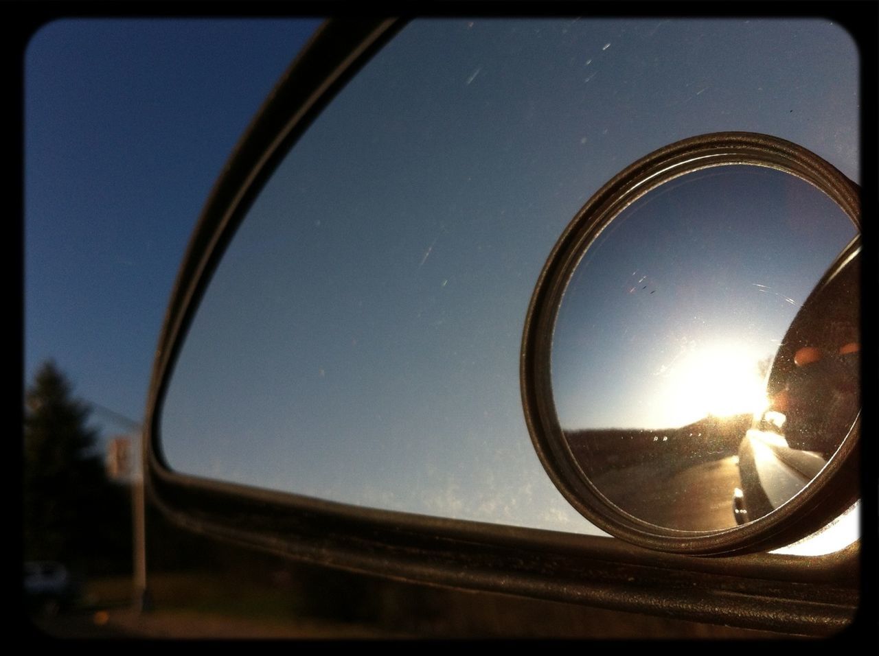 sun, low angle view, glass - material, sky, clear sky, transportation, lens flare, sunlight, mode of transport, car, part of, transparent, illuminated, reflection, circle, sunbeam, window, fish-eye lens, land vehicle, built structure