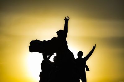 Low angle view of silhouette statue against sky during sunset