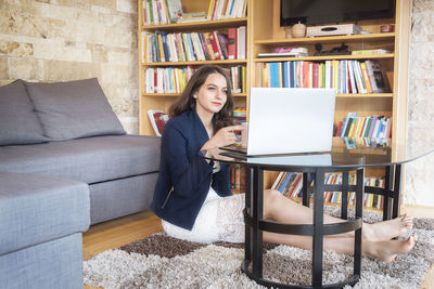 Woman sitting on sofa at home