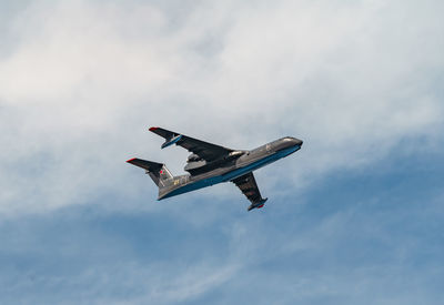 Low angle view of airplane flying against sky