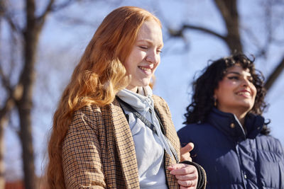 Smiling female friends walking in park