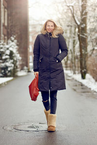 Portrait of mature woman in warm clothing standing on street