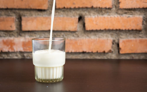 Close-up of drink on table against wall