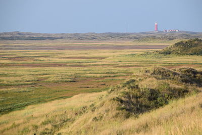 Scenic view of fields against clear blue sky