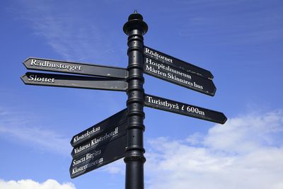 Low angle view of road sign against blue sky