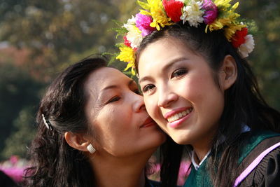 Close-up of mother kissing daughter in sunny day
