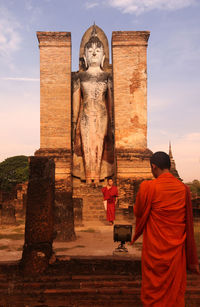 Monks against buddha statue at temple