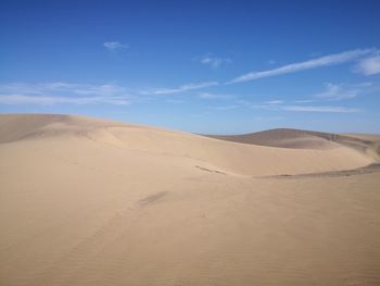 Scenic view of desert against blue sky