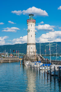 Lighthouse by sea against sky