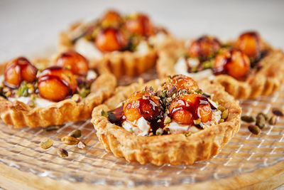 Tartlets with melon, mascarpone and pistachios on transparent plate