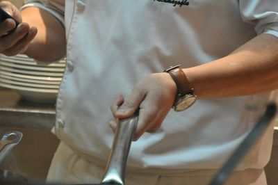 Midsection of chef holding spoon