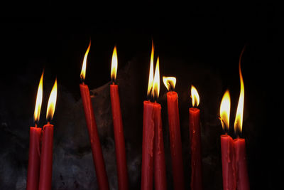 Close-up of burning candles at night