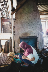 Rear view of woman working on staircase of building