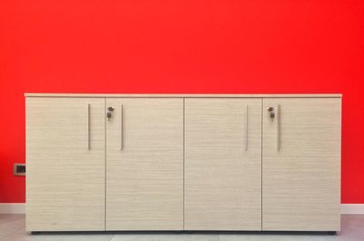 Cabinet against red wall in office