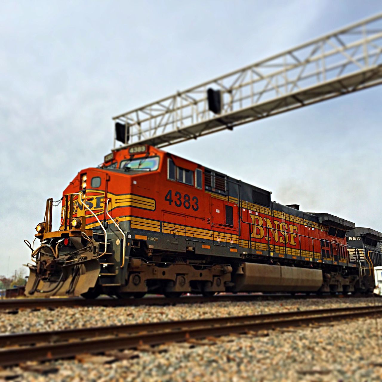 railroad track, rail transportation, transportation, sky, architecture, built structure, public transportation, low angle view, metal, train - vehicle, railing, bridge - man made structure, connection, railroad station platform, day, text, railroad station, western script, travel, outdoors