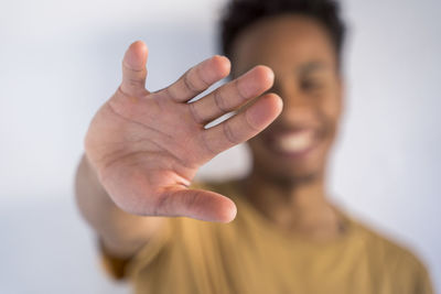 Young man gesturing against white background