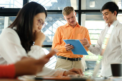 Low angle view of male colleagues discussing in office