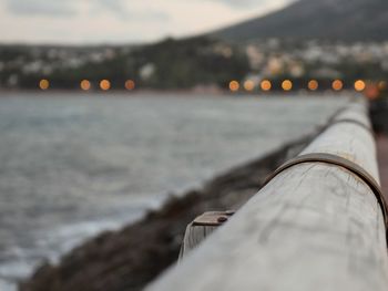 Close-up of umbrella by sea against sky during sunset