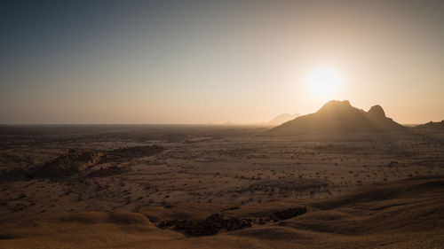 Scenic view of desert against sky during sunset