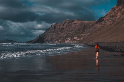 Man standing on beach against sky