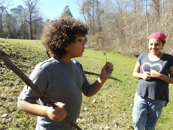 Brother and sister standing on grassy field at natchez trace parkway