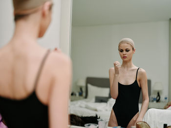 Side view of young woman standing at home