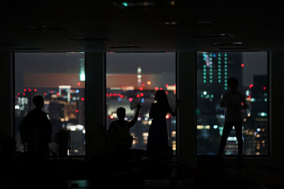 Silhouette people standing in airport at night