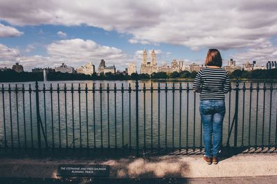 Rear view of woman standing on bridge