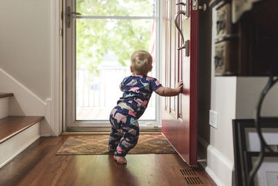 Baby girl standing at doorway