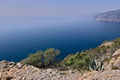 High angle view of rocks by sea against sky