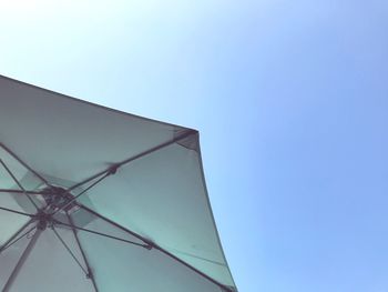 Low angle view of telephone pole against clear blue sky