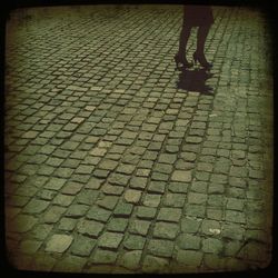 Low section of woman standing on tiled floor