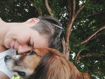 Woman with dog against trees