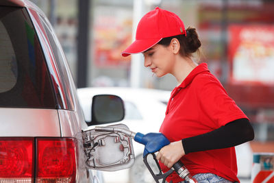 Female worker filling gas in car