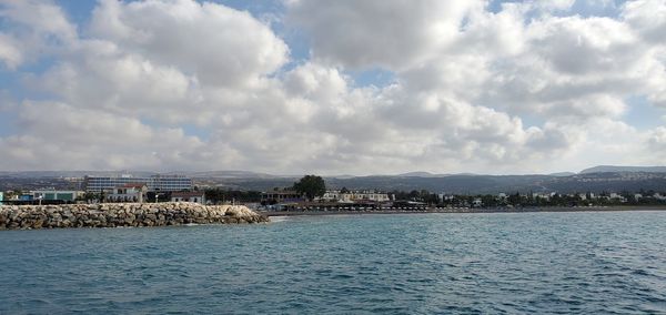 Panoramic view of sea and buildings against sky