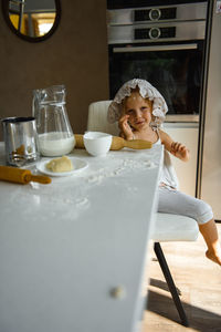 Little girl cooking pizza in the kitchen