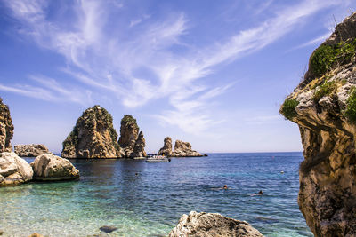 Scenic view of rocks in sea against sky