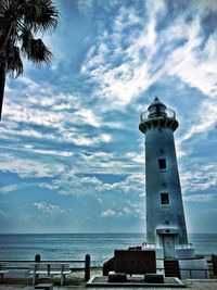 Lighthouse by sea against sky