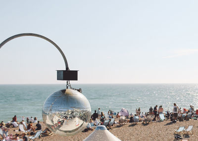 Reflection of brighton beach on disco ball against clear sky