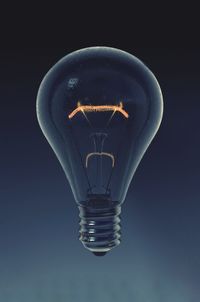 Close-up of light bulb levitating against gray background