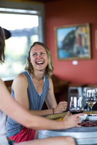 A young woman laughs while enjoying wine at a winery in the dalles, or