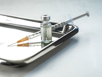 Metal tray with syringe and vial of vaccine