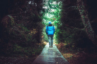 Rear view of man walking on footpath