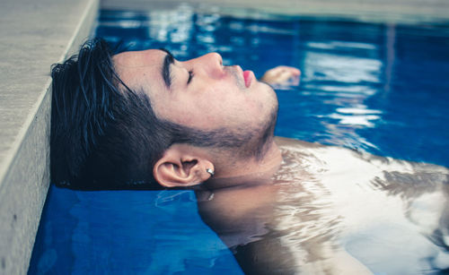 Portrait of young man swimming in pool