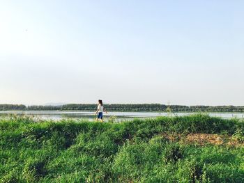 Rear view of man overlooking calm lake