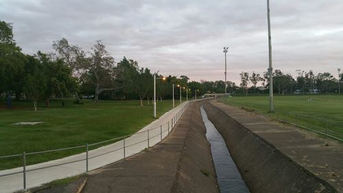 Empty road against cloudy sky