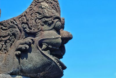 Low angle view of statue against clear blue sky