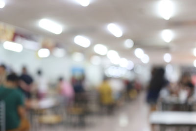 Defocused image of people standing on illuminated street