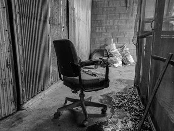 Abandoned chair against wall